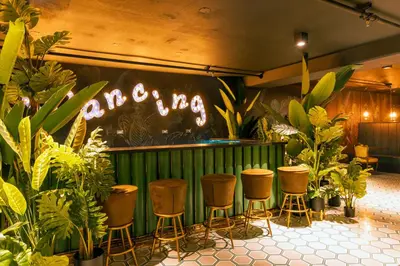 a bar with stools and a sign that says dancing at Studio en piso 29 Secrt Sabana in San José