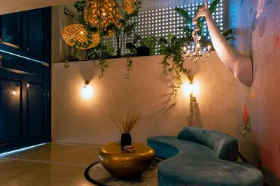 a room with a couch and a table and chandeliers at Studio en piso 29 Secrt Sabana in San José