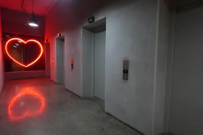 an empty hallway with a heart sign on the wall at Studio en piso 29 Secrt Sabana in San José