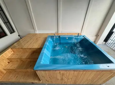 a large blue tub sitting on top of a wooden floor at bambu house in Alajuela City