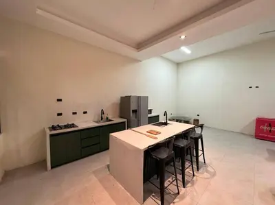 a kitchen with a table and some chairs in it at bambu house in Alajuela City