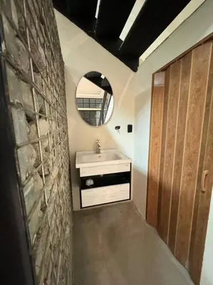 a bathroom with a sink and a mirror at bambu house in Alajuela City