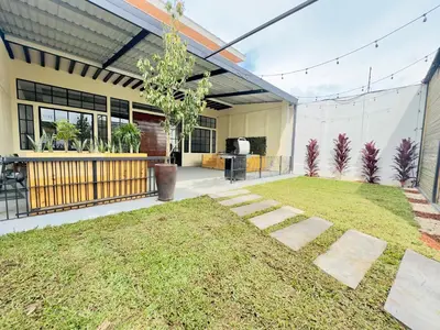 a backyard of a house with a lawn at bambu house in Alajuela City