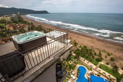 a hot tub on a balcony next to the beach at Spectacular 3 bedroom Penthouse at Crocs Resort Casino in Jacó