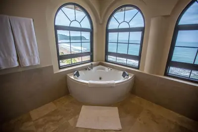 a bath tub in a bathroom with three windows at Spectacular 3 bedroom Penthouse at Crocs Resort Casino in Jacó