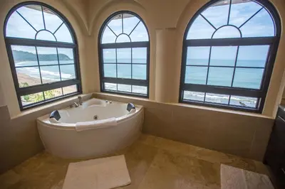 a bath tub in a bathroom with three windows at Spectacular 3 bedroom Penthouse at Crocs Resort Casino in Jacó