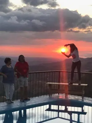 a woman standing on a bench on top of a balcony at Orange Hills -Atenas- in Barrio Jesús