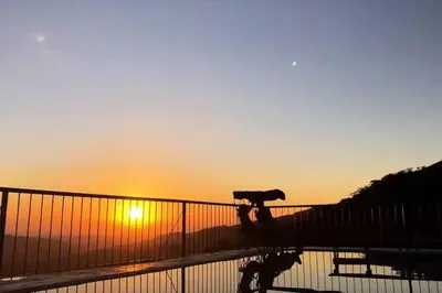 a silhouette of a person riding a skateboard at sunset at Orange Hills -Atenas- in Barrio Jesús