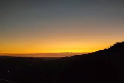 a view of the sunset from the top of a mountain at Orange Hills -Atenas- in Barrio Jesús