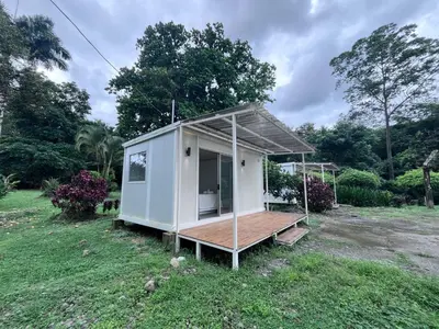 a tiny house with a porch in a field at Cautiva Sleep Inn in Guácimo