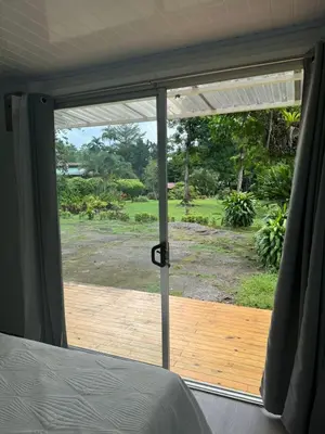 a bedroom with a sliding glass door to a deck at Cautiva Sleep Inn in Guácimo