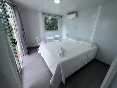 a bedroom with a white bed with a teddy bear on it at Cautiva Sleep Inn in Guácimo