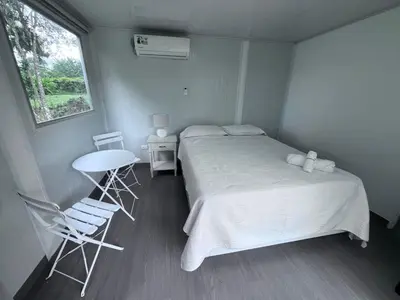 a bedroom with a bed and a table and chairs at Cautiva Sleep Inn in Guácimo