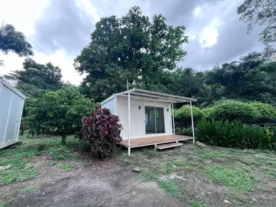 a small white house in a yard at Cautiva Sleep Inn in Guácimo