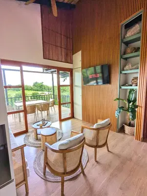 a living room with chairs and tables and a television at Serene Hills in Fortuna