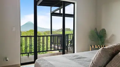 a bedroom with a bed and a view of a balcony at Serene Hills in Fortuna