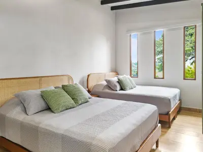 a bedroom with two beds and two windows at Serene Hills in Fortuna
