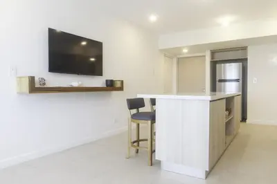 a kitchen with a bar with a tv on the wall at J-PacP506 condo in Jacó