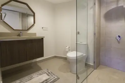 a bathroom with a toilet and a glass shower at J-PacP506 condo in Jacó