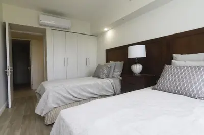 a bedroom with two beds and a dresser with a lamp at J-PacP506 condo in Jacó