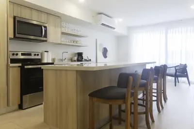 a kitchen with a bar with chairs and a counter top at J-PacP506 condo in Jacó