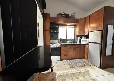 a kitchen with wooden cabinets and a white refrigerator at Designer-Inspired 1Bed1Bath Condo Close to Beach in Coco