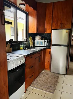 a kitchen with wooden cabinets and a white refrigerator at Designer-Inspired 1Bed1Bath Condo Close to Beach in Coco