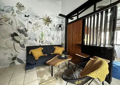 a living room with a blue couch with yellow pillows at Designer-Inspired 1Bed1Bath Condo Close to Beach in Coco