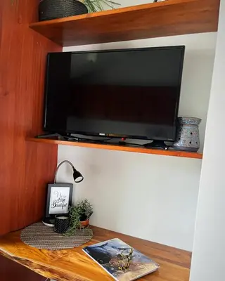 a flat screen tv on a wooden shelf at Designer-Inspired 1Bed1Bath Condo Close to Beach in Coco