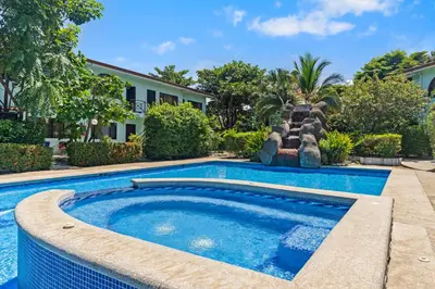 a swimming pool with a water slide in front of a house at Casa Verde 2b2b Completely Renovated Ground Unit in Coco