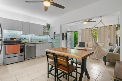 a kitchen and living room with a wooden table and chairs at Casa Verde 2b2b Completely Renovated Ground Unit in Coco