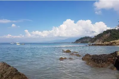 a large body of water with rocks in the water at Apartamento en Manuel Antonio in Quepos