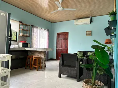 a living room with blue walls and a table and chairs at Apartamento en Manuel Antonio in Quepos