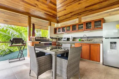 a kitchen with wooden ceilings and a table with chairs at Casita Morpho, high speed wifi in Uvita