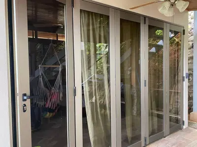 a sliding glass door of a home with a porch at Casita Morpho, high speed wifi in Uvita