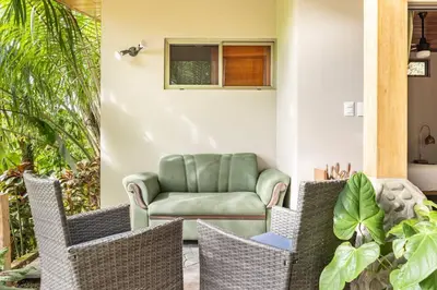 a living room with a chair and a couch at Casita Morpho, high speed wifi in Uvita