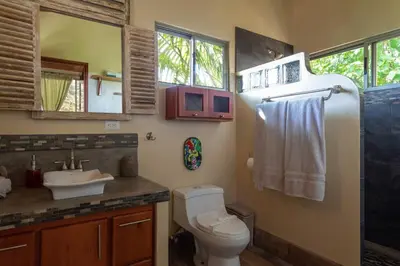 a bathroom with a toilet and a sink at Casita Morpho, high speed wifi in Uvita