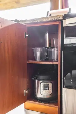 a kitchen cabinet with a toaster oven anduclearuclearuclearuclearuclearuclearuclear at Casita Morpho, high speed wifi in Uvita