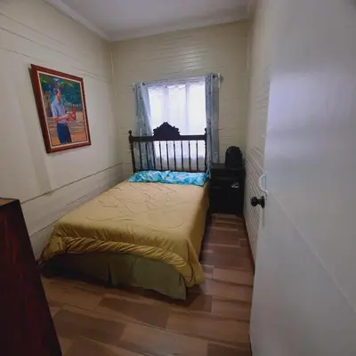 a small bedroom with a bed and a window at The garden suite in Alajuela City