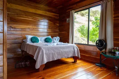 a bedroom with a bed in a room with a window at Cabina vista al valle Monteverde in Monteverde Costa Rica