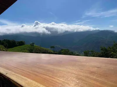 a view of a mountain with clouds in the sky at Cabina vista al valle Monteverde in Monteverde Costa Rica