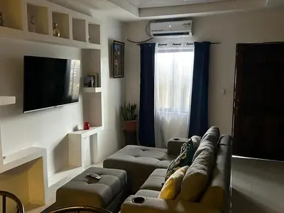 a living room with a couch and a tv at Pura Vida CRC - NO PARKING in Santiago Este