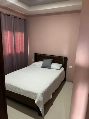 a bedroom with a bed with a blue pillow on it at Pura Vida CRC - NO PARKING in Santiago Este