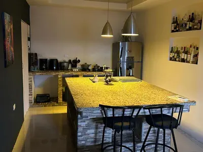 a kitchen with a counter with two bar stools at Pura Vida CRC - NO PARKING in Santiago Este