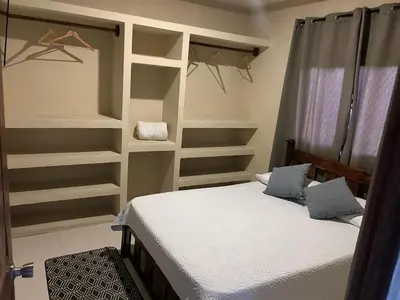 a bedroom with a bed and shelves in a room at Pura Vida CRC - NO PARKING in Santiago Este