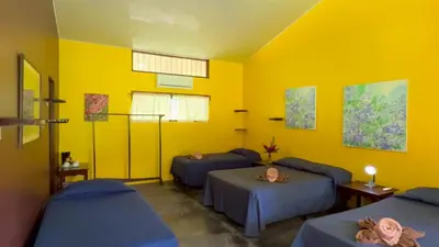 a room with three beds and a yellow wall at Gran Gavilán del Sarapiquí Lodge in Sarapiquí