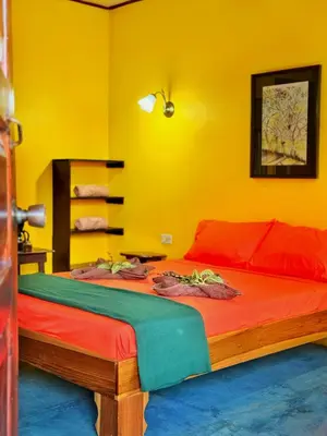 a bedroom with a bed in a yellow room at Gran Gavilán del Sarapiquí Lodge in Sarapiquí