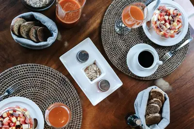 a wooden table topped with plates of food and coffee at Star Mountain Jungle Lodge - Only 4x4 Vehicles, No Meals in Mal País