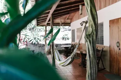 a room with hammocks in a house with a table at Star Mountain Jungle Lodge - Only 4x4 Vehicles, No Meals in Mal País