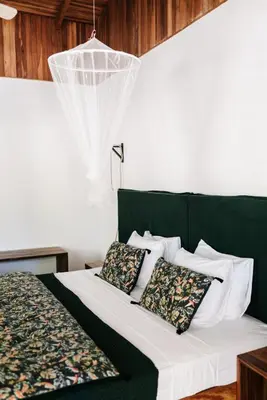a bed with a green headboard and two pillows at Star Mountain Jungle Lodge - Only 4x4 Vehicles, No Meals in Mal País